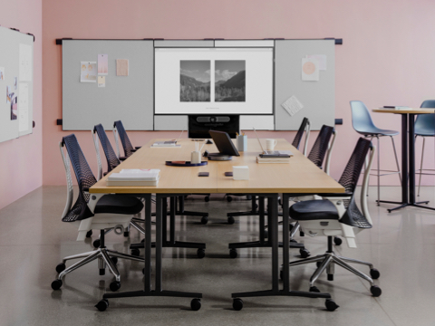 Meeting tables in a Workshop Setting with locker storage and project work pinned on boards attached to the walls. Meeting tables in a Workshop Setting with locker storage and project work pinned on boards attached to the walls.
