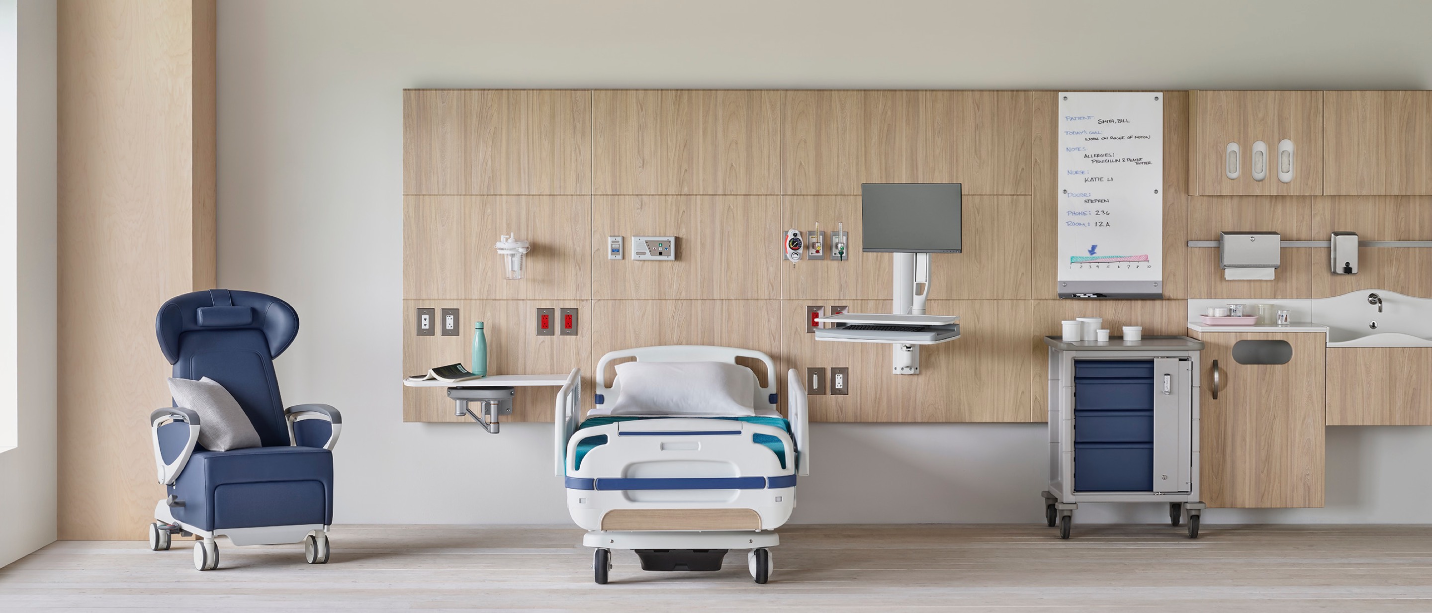 Compass System headwall in a patient room with a blue Ava Recliner and a Procedure and Supply Cart. Compass System headwall in a patient room with a blue Ava Recliner and a Procedure and Supply Cart.