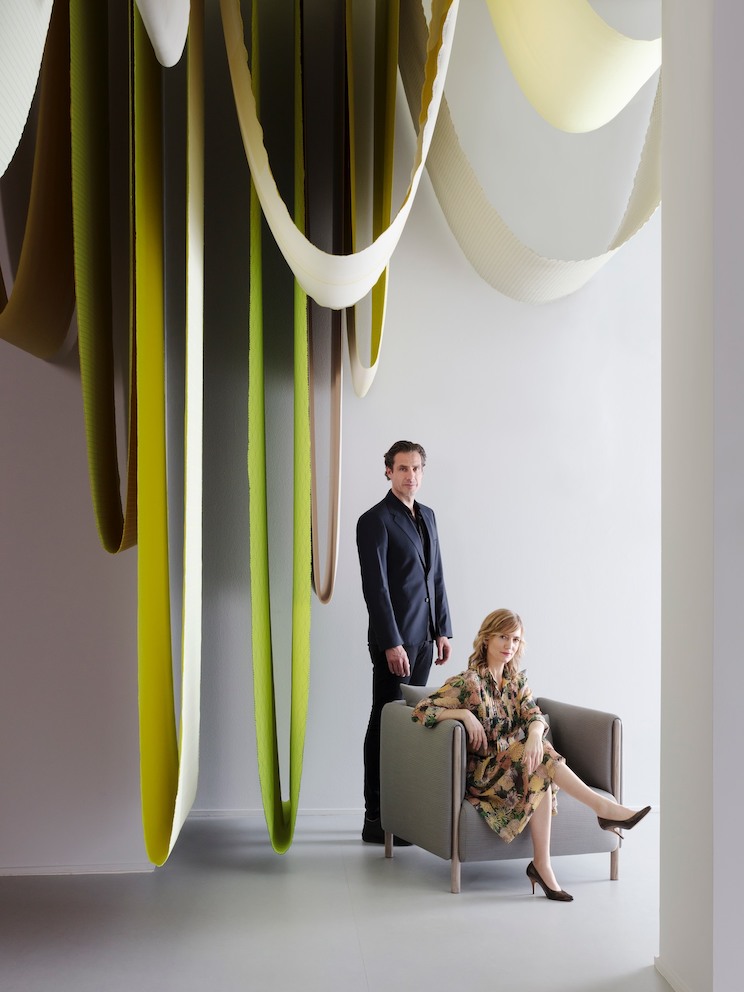 Designers Stefan Scholten, standing, and Carole Baijings, seated, next to hanging textiles. Designers Stefan Scholten, standing, and Carole Baijings, seated, next to hanging textiles.