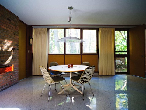 The dining area on the opposite side of the living room features upholstered Eames Wire Chairs and a Nelson Table—both customized to a lower height. Corner recreated the pendant light based on original drawings and photographs. The dining area on the opposite side of the living room features upholstered Eames Wire Chairs and a Nelson Table—both customized to a lower height. Corner recreated the pendant light based on original drawings and photographs.